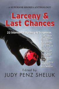 Larceny & Last Chances Anthology Cover Image of a hand in a black glove, lifting a very large faceted ruby.